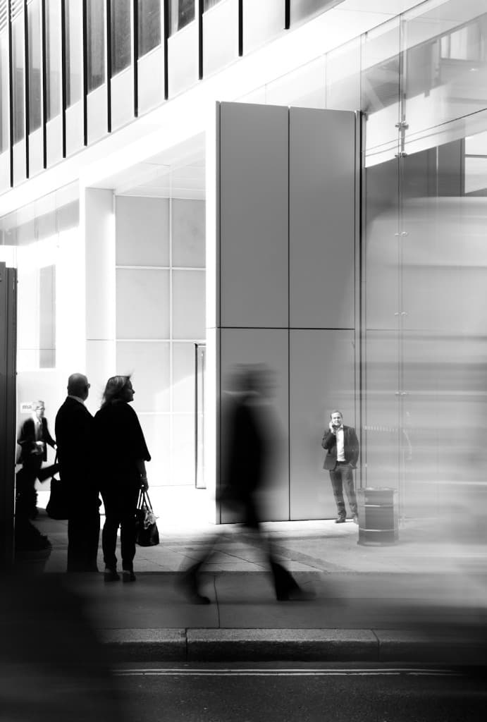 Business professionals outside a modern glass office building
